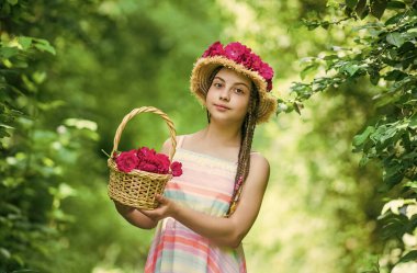 Sevgiyle büyüdü. Yaz tatili ve tatil. Kadın güzelliği ve moda. çocukluk mutluluğu. Mutlu çocuk çiçek topluyor. Bahar parkında ya da bahçede çocuk yürüyüşü. Yazlık gül buketli küçük kız.