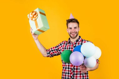 Kareli gömlekli genç adam parti balonları ve hediye kutusu, tatil