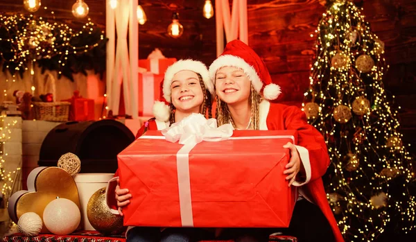 Vintermaskerad. Lycka och glädje. Flickvänner systrar Santa claus kostymer fick gåva. Tomtens besättning. Tomtefest. Gott nytt år. Barn har kul på julafton. Jättestor överraskning — Stockfoto