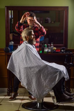 Sakallı adam. Bıyıklı ve sakallı hippi. Adam yeni saç stili istiyor. Erkek güzellik ve moda. Berber dükkanında olgun bir adam. Kuafördeki vahşi sakallı adam. Erkek müşterisi olan profesyonel berber.