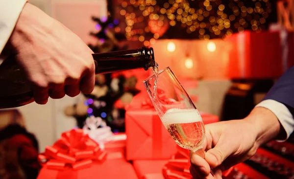 Celebre o Ano Novo com o champanhe. Mãos derramando champanhe em vidro elegante fundo decorações de Natal. Um conceito de saúde. Último minuto antes do ano novo. Beba champanhe ou espumante — Fotografia de Stock