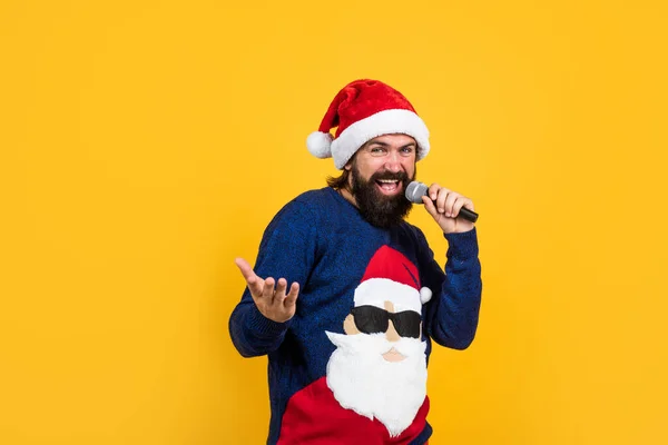 Vousatý Santa muž zpívající v mikrofonu v klobouku s úsměvem při přípravě na oslavu šťastný Nový rok párty a vánoční prázdniny v zimě bude mít vánoční dárky, vánoční zpěvák — Stock fotografie