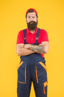 Sakallı olgun bir işçi üniforma giyer, tamir eder.