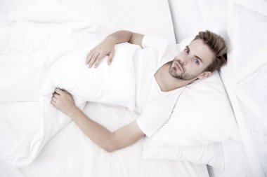 Sabahın erken saatlerinde baş ağrısına neden olur. Migren ağrısı. Uyku problemleri sabahları baş ağrılarına yol açabilir. Yatakta dinlenen yakışıklı adam. Horlamak baş ağrısını artırabilir. Uyku apnesinin yaygın belirtisi.