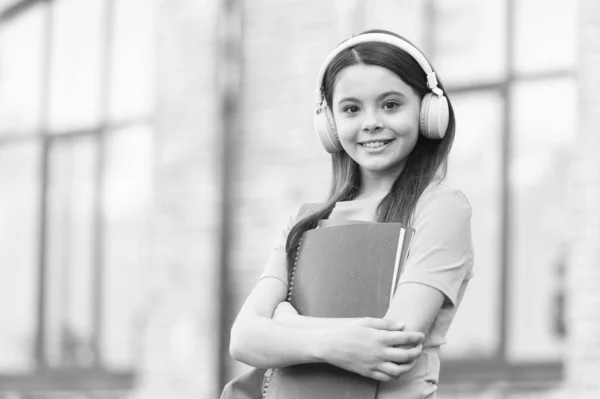 Aprender lengua extranjera. Niña pequeña aprende inglés. Un niño pequeño sostiene libros ingleses. Habilidades de comprensión auditiva. Literatura inglesa. Gramática inglesa. Clases privadas. Bienvenido a la escuela de idiomas — Foto de Stock