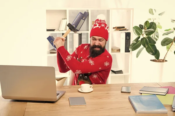 Más notícias. Hipster irritado bateu laptop com martelo. O homem barbudo de roupa de Natal ficou zangado. Estar zangado com problemas de negócios. Estresse no local de trabalho. Sinto-me zangado. Mau humor — Fotografia de Stock