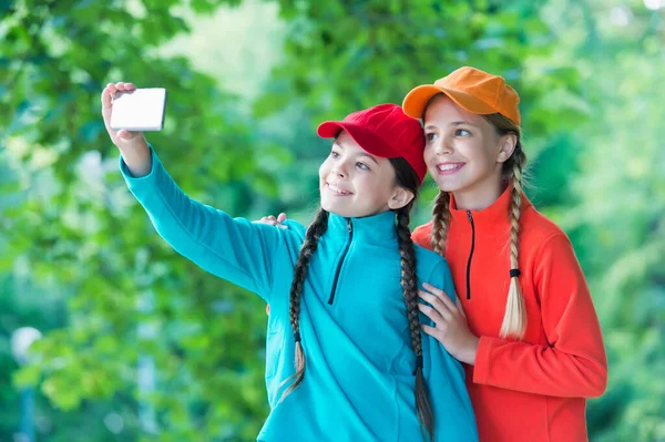 Happy girls with beauty look pose for selfie camera phone on natural landscape, self-portrait photos — Stock fotografie