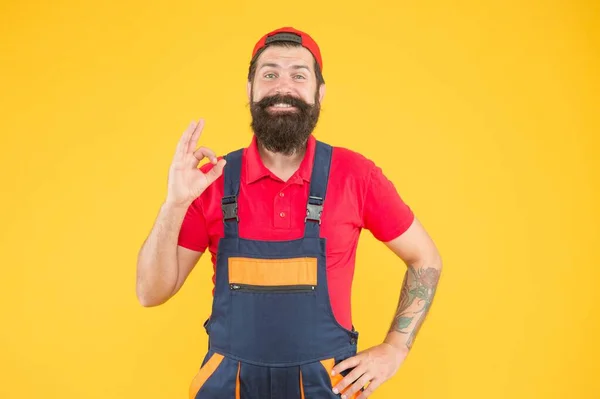 Eu aconselho-te. homem trabalhador em macacões e boné. construtor trabalhador masculino ou engenheiro. serviço mecânico maduro. Encanador qualificado. reparador depois de terminar o trabalho. brutal barbudo homem no uniforme — Fotografia de Stock