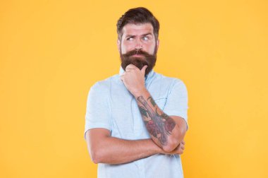 Beyaz gömlekli, sakallı, düşünceli bir adam.