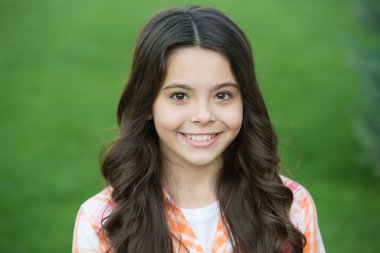 Doğal olmak daha şık. Uzun saçlı, yeşil çimenli mutlu kız gülüşü. Küçük çocuğun güzel görünüşü. Kuaför salonu. Şampuanlama ve kondisyon. Yeni kusursuzluğu paylaş