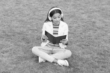 hayal gücünün gelişimi. Şirin kız kitap okuyor. Okul bahçesinde kitabı olan mutlu anaokulu kızı. Okula dönüyorum. Kulaklıklı, çalışkan bir çocuk. Eğitim ve okuma kavramı. Yazar ol.