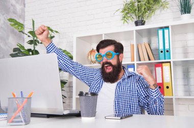 - Evet. Mutlu hipster zaferi internette kutluyor. Sakallı adam kazanan hareketi yapar. Online video oyunu oynuyorum. Gerçek ödülü kazanmak. Zafer ve başarı. Modern teknoloji. Oyna ve kazan