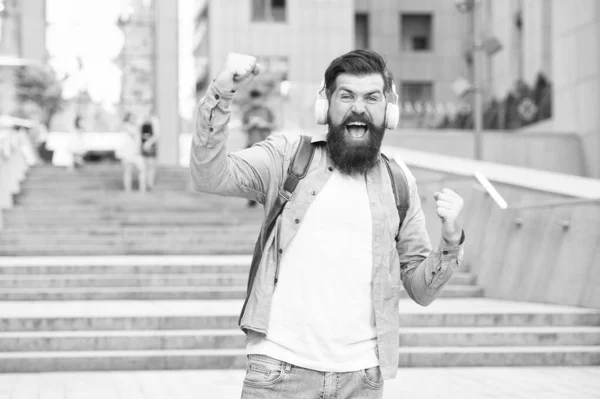 Conceito de energia. Alegria e positividade. Caminho para o trabalho. Sozinho com música. Livre e feliz. Vida moderna. Homem com auscultadores a andar no centro da cidade. A ouvir música. Bonito hipster com mochila. Bom som. — Fotografia de Stock