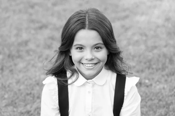 Ella es tan linda. Feliz infancia. de vuelta a la escuela. Una niña pequeña usa uniforme escolar. belleza y moda. hermosa estudiante adolescente chica en parque. lindo sonriente confiado colegiala relajarse en verde hierba — Foto de Stock