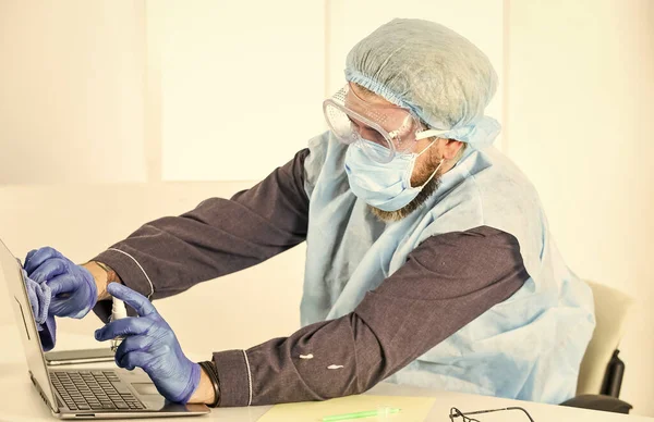 Koruma konsepti. uzaktan çalışma konsepti. Doktor üniformalı adam. Adam solunum maskesi, eldiven ve koruyucu gözlük takıyor. Evde güvende kal. Koronavirüs salgını. Hijyen kilitlendi.