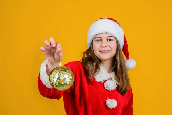 快乐的圣诞小女孩头戴红色的圣诞老人帽，身穿红色的圣诞服装，装饰树木，做好准备 — 图库照片