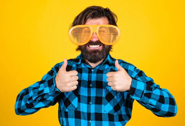 Uomo barbuto in occhiali divertenti. Il tipo brutale indossa una camicia a scacchi. maschio con i baffi divertirsi. Una bella festaiola hipster. felice uomo maturo mostrando pollice in su — Foto Stock