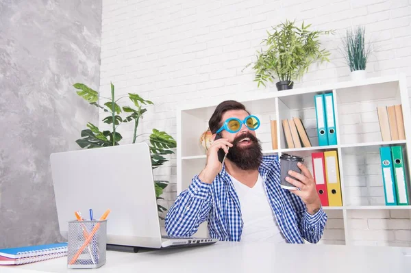 Vahşi görünüşlü sakallı adam rahat gözlük takıyor modern ofiste cep telefonuyla konuşuyor, hippi. — Stok fotoğraf