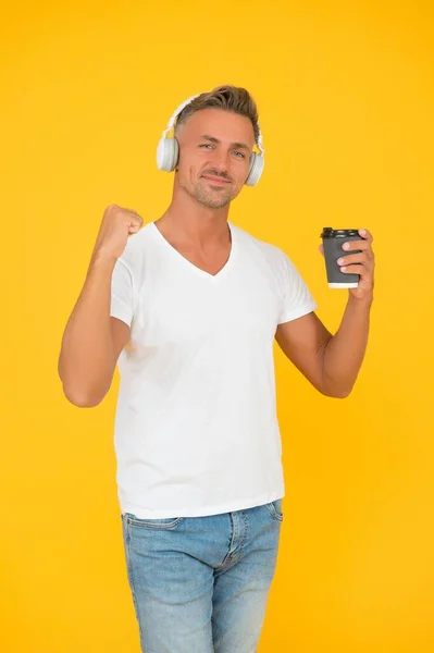 Live life to the full. Happy man hold coffee flexing arm. Strong coffee. Dark roast. Natural energy drink. Takeaway and cafe. Caffeine addicted. Listening to music. Modern technology. Cup of energy — Stock Photo, Image