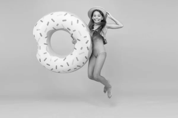 Conceito de recreação. Hotel com piscina. Menina e anel de donut natação. Miúdo de fato de banho a relaxar e a divertir-se. Férias. Miúdo alegre e relaxante. Relaxar na piscina. Resort de verão — Fotografia de Stock