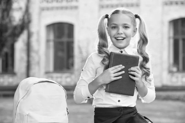 Een klein meisje heeft een boek. Literatuur voor kinderen. ontwikkeling van de jeugd. werken met notebook. terug naar school. Een kind met een schooltas. Een lachend kind met een rugzak. laten we huiswerk maken — Stockfoto