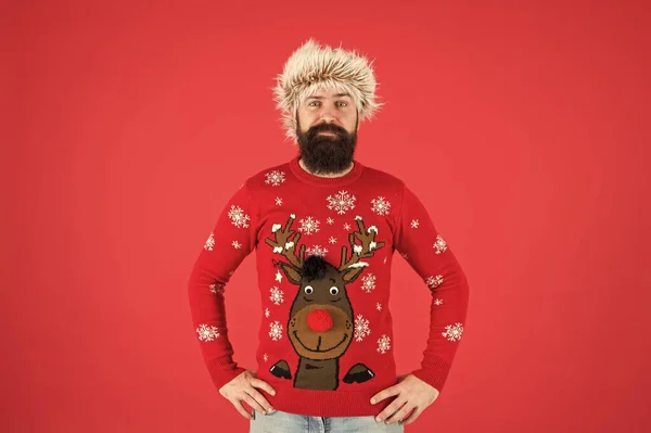 Christmas party time. cold weather fashion for men. happy new year. bearded man on red wall. funny man with beard in knitted sweater. pazzled hipster ready for xmas party. winter holiday celebration — Stock Photo, Image