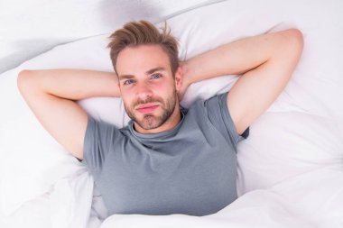 Güne düzenli olarak başlıyor. Yakışıklı adam sabah rutini için uyandı. Bakım rutininden önce yatakta yatan seksi adam. Kutsal rutin adam her sabah...