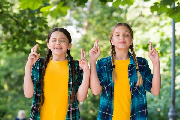Gelukkig kleine meisjes met schoonheid look in casual mode stijl houden vingers gekruist zomer buiten, maken wens — Stockfoto