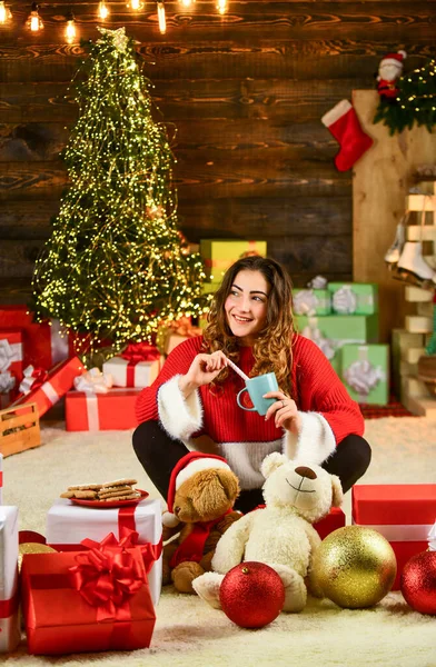 Najlepsze przepisy świąteczne. Szczęśliwa dziewczyna pije mleko z ciasteczkami. kobiecy sweter w prezentach. prezent zimowy wakacje i dekoracji. skład noworoczny. Czuję się przytulnie. miłość trzcina cukrowa — Zdjęcie stockowe