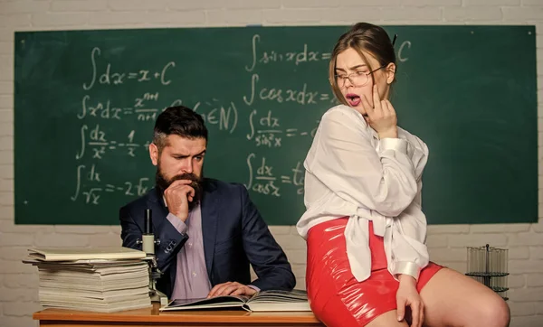 Distracting him from work. Private lesson. Check knowledge. Desire for knowledge. Sex knowledge. Need for real experience. Teacher and student in classroom chalkboard background. Sexy seduction