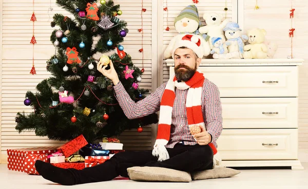 Muž s vousy drží zlaté vánoční koule — Stock fotografie