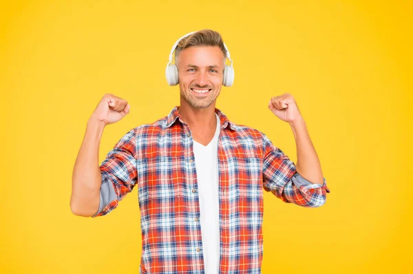 Ευτυχισμένος άνθρωπος κάνει χειρονομία δύναμης κάμψη ισχυρά χέρια ακούγοντας μουσική σε ακουστικά, οδοντιατρική — Φωτογραφία Αρχείου