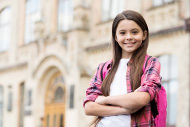 Uluslararası Çocuk Günü. Kendine güvenen çocuk okul bahçesinde kollarını kavuşturur. Okul eğitimi. 20 Kasım. Çocuklar Günü 'nde. Mutlu bir çocukluk. Parlak bir gelecek hayal etmek, boşluğu kopyalamak