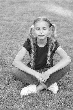 Hayalindeki geleceği yarat. Yeşil çimlerde tatlı hayalperest. Küçük çocuklar için açık havada rüya gibi bir yaz. Küçük kız doğal manzaraya kapalı gözlerle rahatlıyor. Hayallerimdeki iş. Hayal et ve parla