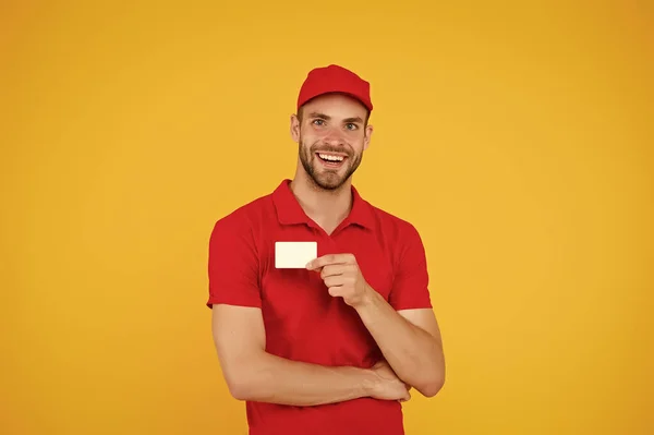 Fico feliz por servir. Homem boné vermelho fundo amarelo. Entregando compra. Entregue ao seu destino. Entrega de serviços. Correio e entrega. Trabalhador da entrega de carteiros. Cartão de desconto. Contacto comercial — Fotografia de Stock