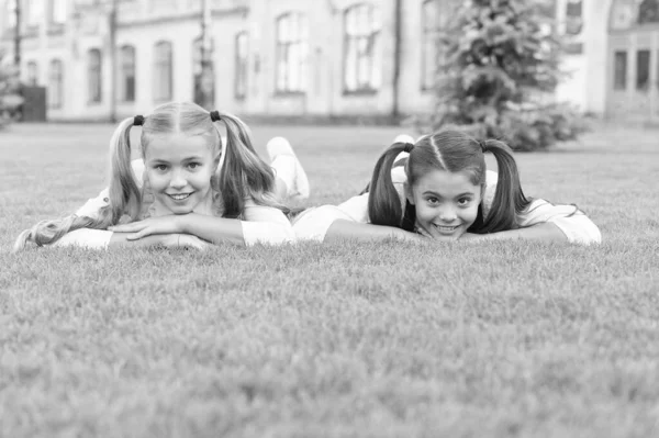 Siente el espíritu del verano. Los niños felices se relajan en la hierba verde. Vacaciones de verano. Vacaciones escolares. Cosméticos de verano para niños. Cuidado de la piel y productos para el cuidado del cabello. Salón de belleza. La hora de verano es la mejor de lo que puede ser —  Fotos de Stock