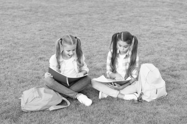 Schoolgirls little children school yard with books, interesting reading concept — Stock Photo, Image