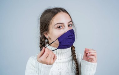 Hasta ve yorgun. Kızın igg bağışıklık testine ihtiyacı var. Virüs zatürresi. Hasta çocuk solunum maskesi takıyor. Koronavirüs salgını sırasında güvenlik önleyici maddeler. Covid 19 'un belirtileri