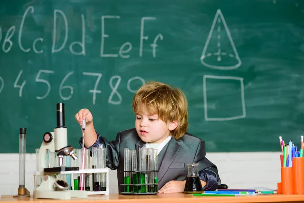 Wissenskonzept. Kind studiert Biologie Chemie. Wissenstag. Grundkenntnisse Grundschulbildung. Glückliche Kindheit. Kinder lernen gern. Junge in der Nähe von Mikroskop und Reagenzgläsern im Klassenzimmer — Stockfoto