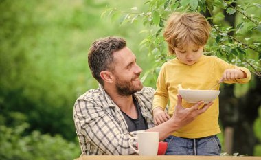 Sağlıklı yemek ve diyet. Süt ürünleri. Babalar günün kutlu olsun. Babasıyla küçük çocuk mısır gevreği yiyor. Aile yemeği zamanı. Baba oğul dışarıda yemek yiyorlar. Sabah kahvaltısı. Vejetaryen diyeti. Birlikte eğleniyoruz.
