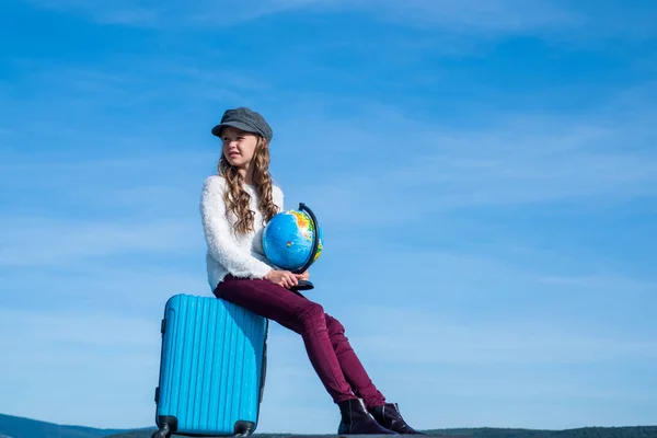 Tiener meisje met globe en reistas op lucht achtergrond, kopieerruimte, reizen — Stockfoto