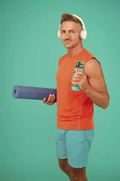 Твои мышцы хотят пить. Спортсмен держит бутылку с водой. Тренер по йоге. Тренер по фитнесу. Жажда тренировок или тренировок. Жажда и обезвоживание. Жажда выпить. Пейте воду, избегайте жажды — стоковое фото