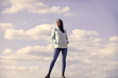 Bulutların üstünde. Uzaklara bakmak, özgürlük duygusu. Gelecek ve başarı. Yaşam tarzı konsepti. Gündelik ceketli modaya uygun bir kız. Sonbahar ve bahar tarzı. Gökyüzü arka planında genç ve güzel bir kadın