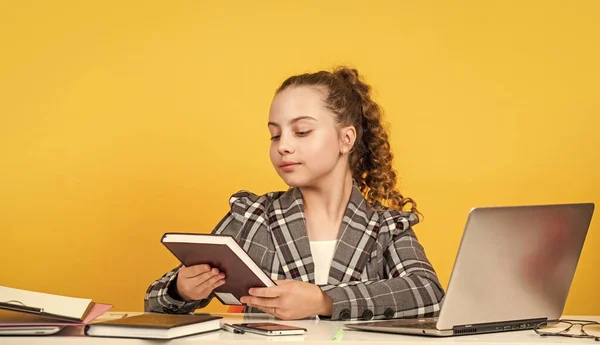 lets read book. schoolgirl has online homework. back to school. time to study. small girl in office. little businesswoman. happy childhood. kid with curly hair wear jacket. work on laptop