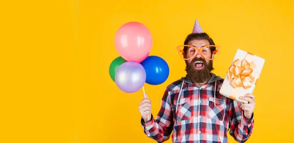 Hombre guapo maduro en camisa a cuadros con globos de fiesta y caja actual, día de fiesta —  Fotos de Stock