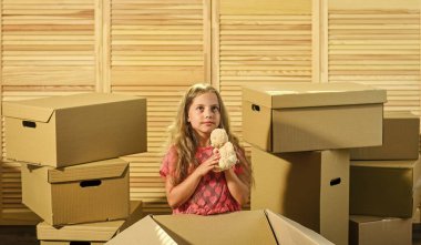 Paketleme işleri. Tek gerçek dost. Kız çocuğu kutuların yanında oyuncakla oynuyor. Konsepti çıkar. Stresli bir durum. Boşanma ve ayrılık. Aile sorunu. Harekete hazırlanın. Harekete geçiyoruz. Taşıma rutini