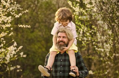 Birlikte bahçeyi keşfediyoruz. Mutluluk kavramı. Basit mutluluk. Mutlu bir aile. Bahar yürüyüşü. Babalık mutluluğu. Babalar Günü. Doğada yaşayan küçük bir çocuk ve baba. Hippi ve küçük oğlu.