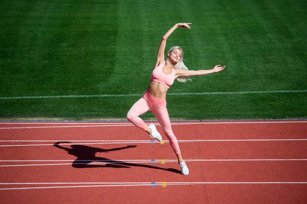 Glad och sportig. bantning sexig dam i träningskläder. sträcker sig ut på utomhusarenan. träning och träning. Atletisk kvinnlig tränare. Kvinnlig idrottstränare. hälsosam sportig livsstil. hälsa och energi — Stockfoto