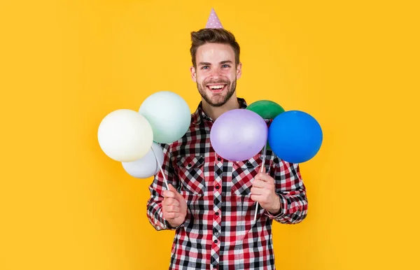 Tüylü balonları tutan sakallı adam. Hazırlık ve kutlama. Parti eğlencesi. Alışveriş satışı. Kareli gömlekli mutlu doğum günü çocuğu. Tatil aksesuarlı şık erkek. — Stok fotoğraf