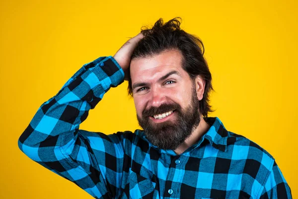 Unshaven sorriso masculino tocar seu cabelo com barba exuberante, salão de cabeleireiro — Fotografia de Stock